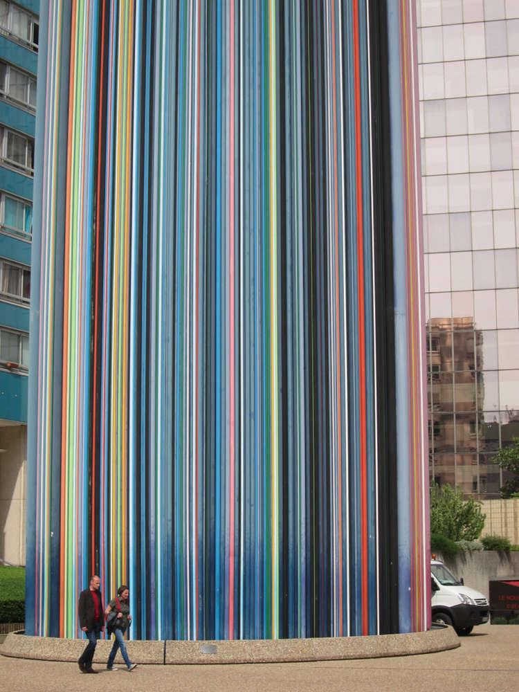 A multicoloured, striated chimney juts into the sky of La Defénse