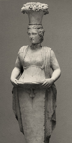 A statue of Hermaphroditos lifting up Their skirt to reveal a set of male genitalia.