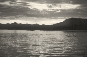 A sunset over mountains and a lake.
